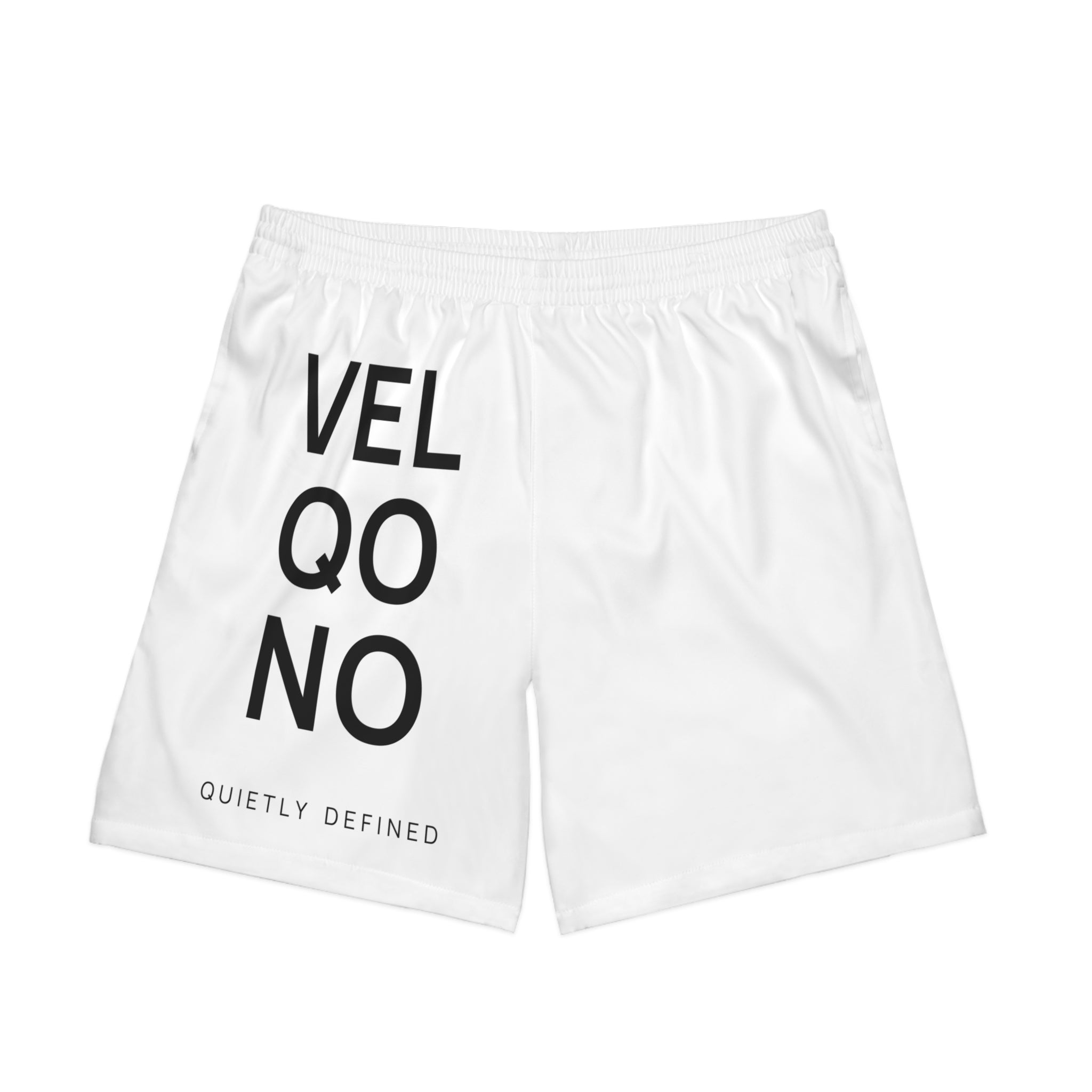 White athletic shorts with black text reading 'VEL QO NO' and 'QUIETLY DEFINED' on the left leg, shown on a plain white background.